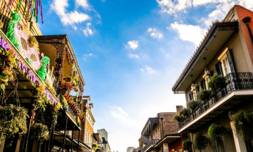 Street view of New Orleans with colorful buildings and musicians playing jazz.