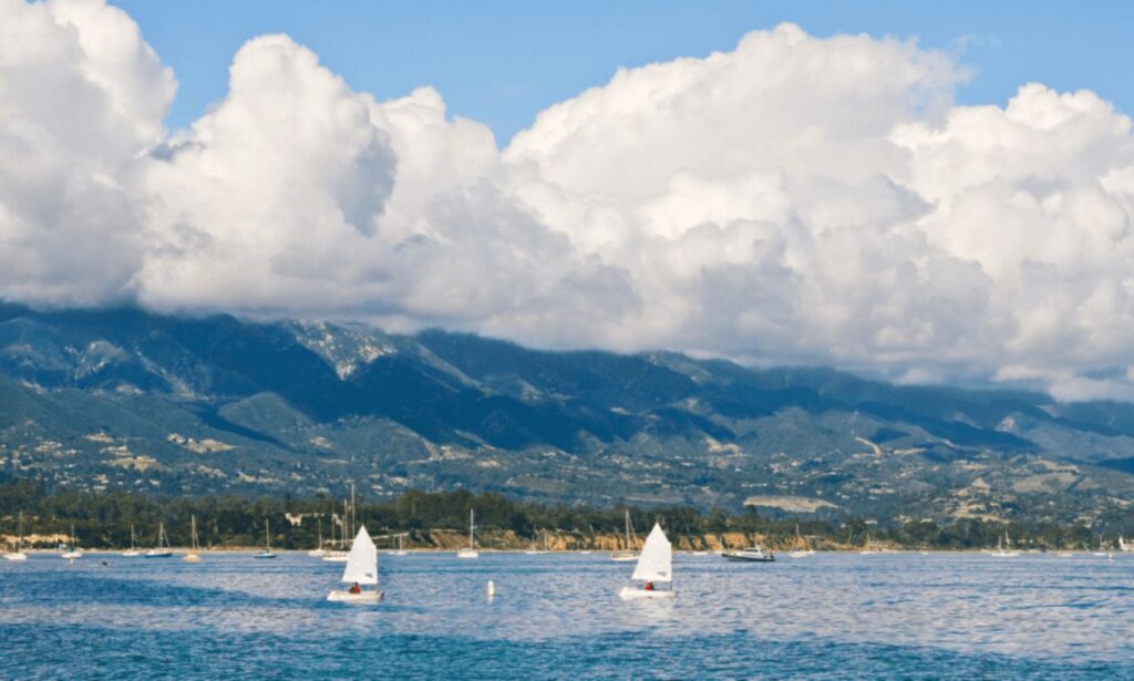 A scenic view of Santa Barbara’s coastline with palm trees, sandy beaches, and Spanish-style buildings.