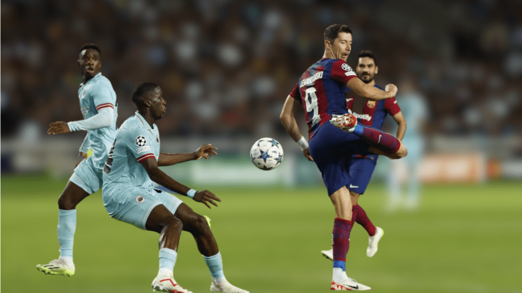 In the Champions League Group H match between FC Barcelona and Royal Antwerp at Estadi Olimpic Lluis Companys in Barcelona, Spain on September 19, 2023, FC Barcelona's Robert Lewandowski is seen in action alongside Royal Antwerp's Soumaula Coulibaly.