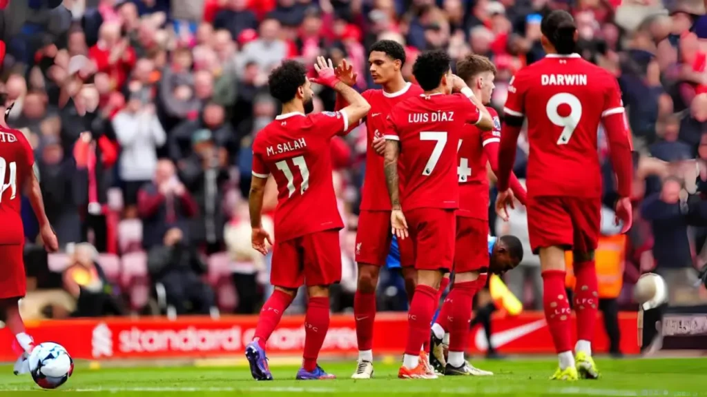 Mo Salah is being surrounded by fans after scoring the game-winning goal against Brighton at home. The win put Liverpool two points ahead of Brighton at the top of the Premier League table.