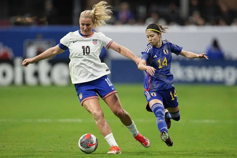 During the second half of a SheBelieves Cup women's soccer game in Atlanta on April 6, 2024, United States' Lindsey Horan (10) blocks the ball from Japan's Yui Hasegawa (14). The US won by a score of 2-1.
