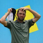 Scottie Scheffler reacting after a difficult shot on a windy and challenging golf course.