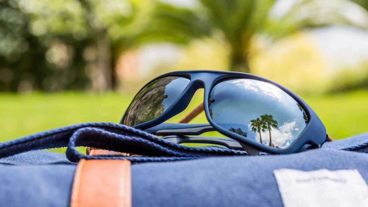 A variety of running sunglasses displayed on a wooden table, showcasing different styles and colors suitable for athletes.